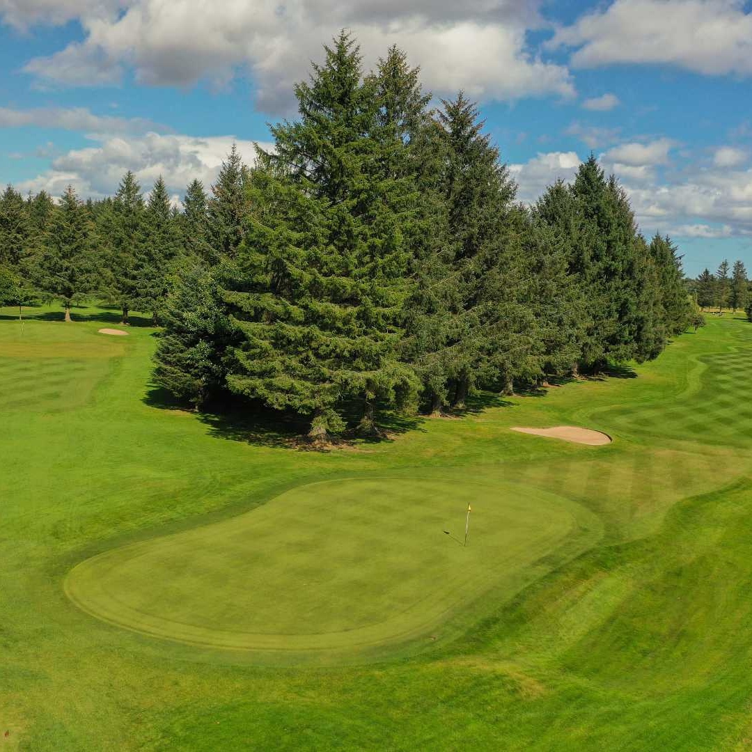 Golf green with bunkers on the Blairs 9-hole course at Deeside Golf Club