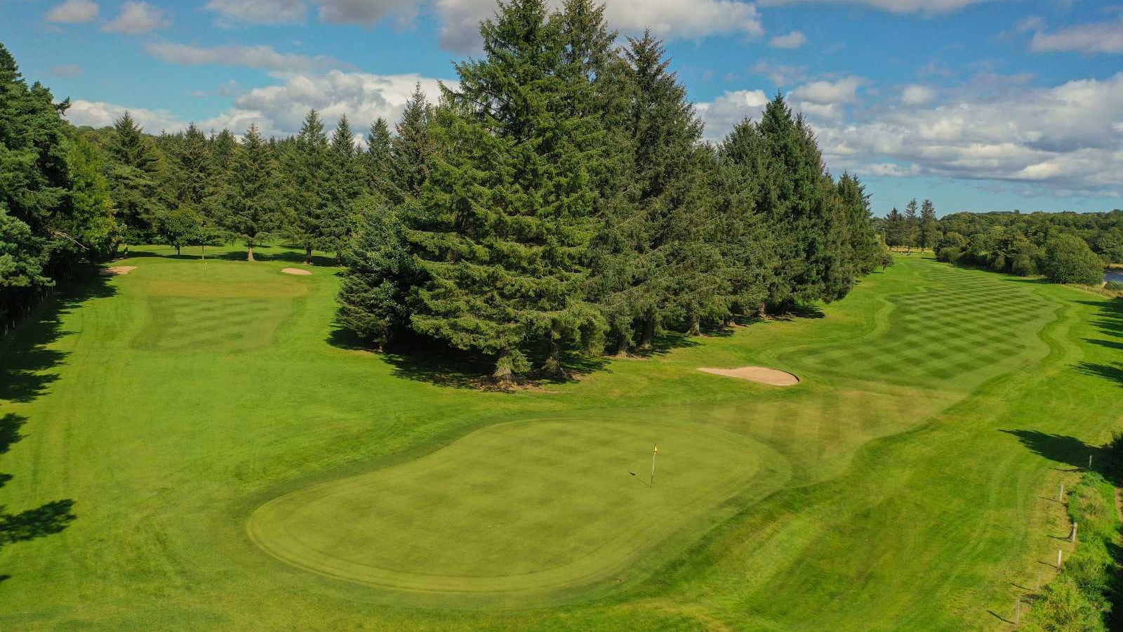 Golf green with bunkers on the Blairs 9-hole course at Deeside Golf Club