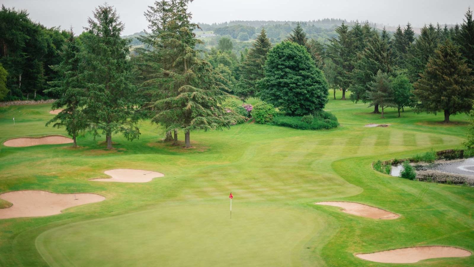 Golf green with surrounding bunkers on the Haughton Course at Deeside Golf Club