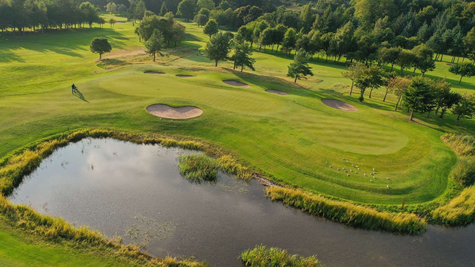 Aerial view of a green, bunkers and pond on the Haughton Course at Deeside Golf Club