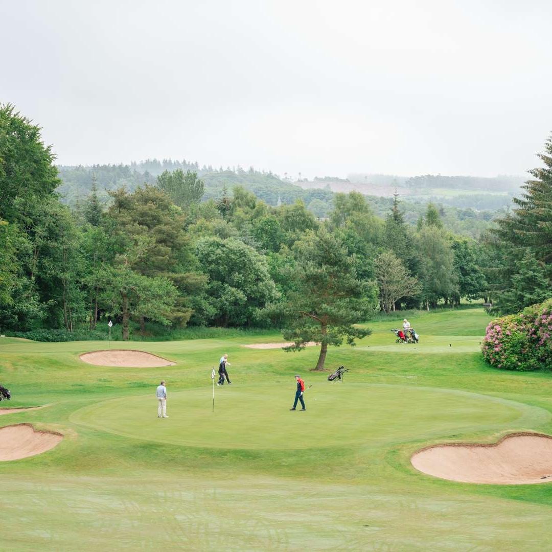 Golfers on a green surrounded by bunkers on the Haughton Course at Deeside Golf Club