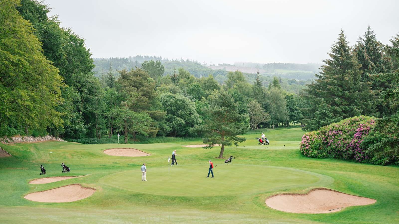 Golfers on a green surrounded by bunkers on the Haughton Course at Deeside Golf Club