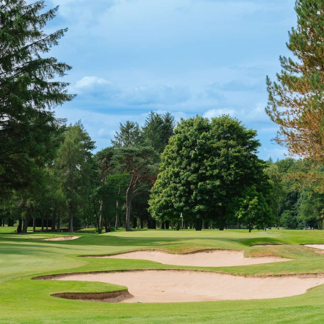 Golf green with bunkers and mature trees on the Haughton Course at Deeside Golf Club